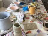 Adults create with clay